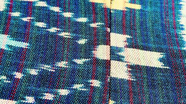 Handwoven ikat textile featuring colorful geometric patterns. Perfect for backgrounds, fashion, interior design, and cultural themes.