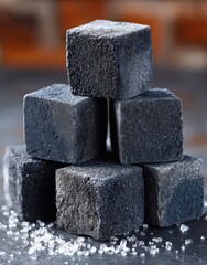 Dark grey, square, marshmallow-like treats stacked