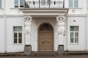 Entrance of Tyszkiewicz manor featuring Atlantes sculptures in Vilnius, Lithuania