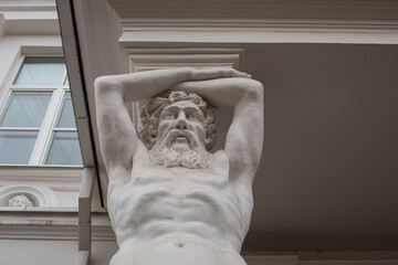 Entrance of Tyszkiewicz manor featuring Atlantes sculptures in Vilnius, Lithuania