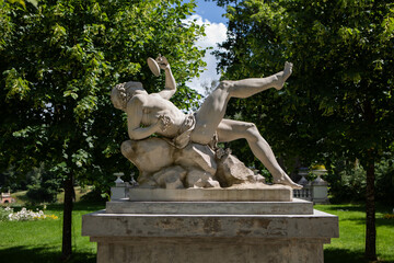 Classical marble statue surrounded by lush greenery in Uzutrakis manor park, Lithuania