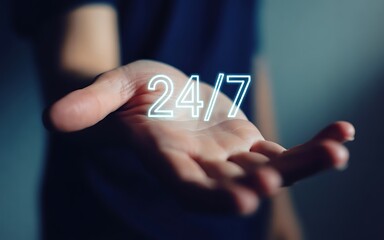 A digital concept of constant service with a glowing 24/7 neon sign floating over an open hand, symbolizing non-stop business support, technical assistance, and online availability