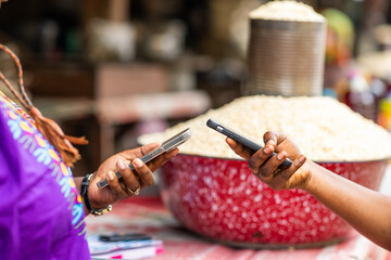 Digital mobile money payment for fresh grains at vibrant African local outdoor market.