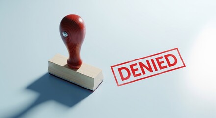 Document Denial: A close-up shot of a rubber stamp imprint and a DENIED stamp, conveying a sense of rejection, disapproval, or refusal.