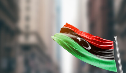 Libya national flag waving on street. A beautiful with mast with blur buildings. Libya national flag for independence day.