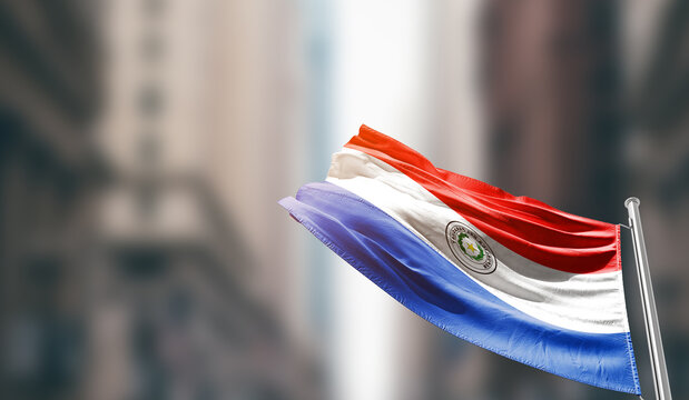 Paraguay national flag waving on street. A beautiful with mast with blur buildings. Paraguay national flag for independence day. - Powered by Adobe