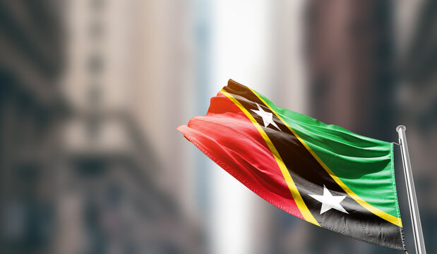 Saint Kitts and Nevis national flag waving on street. A beautiful with mast with blur buildings. Saint Kitts and Nevis national flag for independence day.