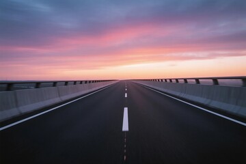 A long highway stretching under a colorful sunset sky