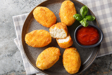 Hot chicken bechamel croquettes with ketchup close-up in a plate on the table. Horizontal top view from above