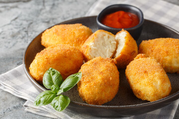 Breaded and fried chicken Croquettes served tomato sauce close-up in a plate on the table. Horizontal