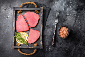 Freshly sliced raw tuna loin fillet, packed with flavor and nutrients, waiting to be transformed into exquisite seafood dishes. black background. top view