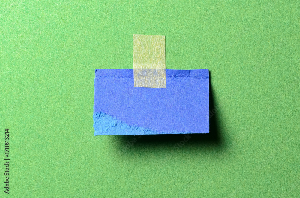 Poster piece of blue paper note cardboard with rough texture edges and adhesive tape with copy space for te
