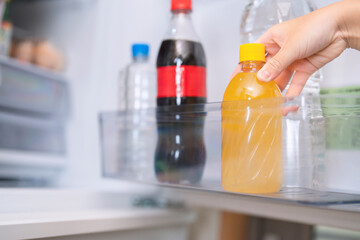 take a juice plastic bottle from the fridge.  冷蔵庫からジュースのペットボトルを取る