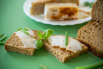 Traditional Ukrainian dish with lard and greens on a green background