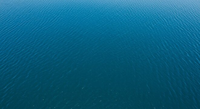 Serene aerial perspective of a deep blue lake with gently rippling water