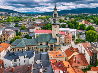 Aerial view of historic town square in Bielsko-Biała, Poland with colorful buildings and mountains in the background.