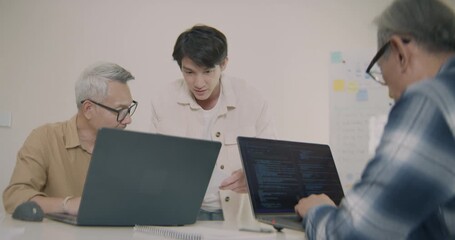 Asian senior adults learning technology and programming with young mentors in an office training class, showing teamwork, coding education, and digital literacy across generations. - Powered by Adobe