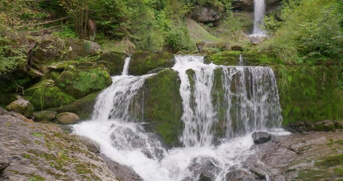 Giessbach falls in Brienz, Switzerland, September 14, 2025. Famous waterfall cascading in the forested ravine above lake Brienz. Overcast summer day, real time, panning shot