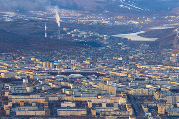 City of Magadan. Top view of city blocks, streets and buildings. Big northern city. In the distance are the smoking chimneys of a thermal power plant. Beautiful cityscape. Magadan region, Russia.