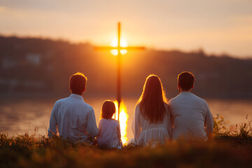 A family of four sits peacefully by a lake at sunset, facing a glowing cross symbolizing faith and unity in a serene, spiritual moment