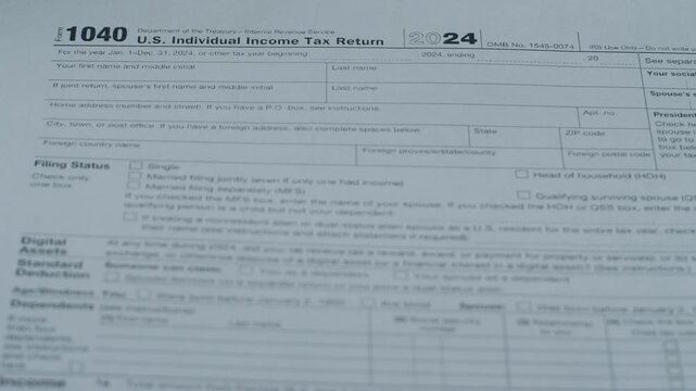 A close-up of multiple 1040 tax forms, the concept of paying personal taxes, and tax legislation.