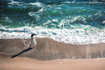 A beautiful woman walks along the beach