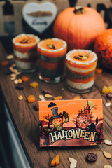 Halloween themed pumpkin desserts on wooden table.