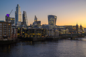 Sunrise over the Thames River illuminating London's skyline with vibrant colors