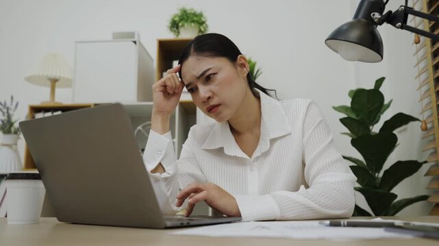 stressed young woman headache while working with laptop computer at home office