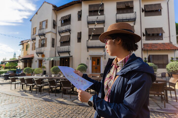 A woman is looking at a tourist attraction map.