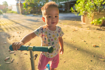 Asian boy playing scooter
