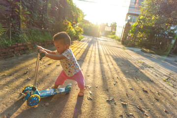 Asian boy playing scooter