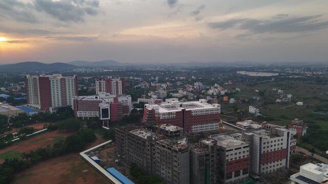 Aerial view of urban development near a large lake. Footage shows modern residential buildings, some finished and some under construction, highlighting the growth of a new city district. VIT Chennai