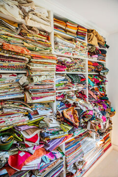 Pieces of cloth in shelves of a seamstresses shop.