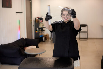 The tattoo artist prepares the worker for work by wrapping the rack with plex film