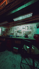 Interior of an old auto repair shop featuring a dimly lit room with a long counter and stools.