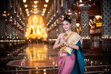 Beautiful young Asian woman in traditional Myanmar dress in an old temple in Chiang Mai, Thailand. 