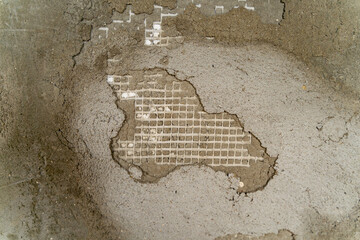 Wall with a crumbling top layer revealing underlying mesh, highlighting signs of aging or poor workmanship, suitable for construction, renovation, engineering, materials and building inspection topics