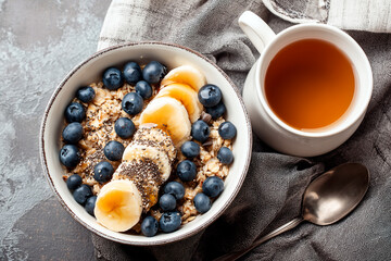 A healthy breakfast bowl with oatmeal, fresh blueberries, banana slices, and chia seeds