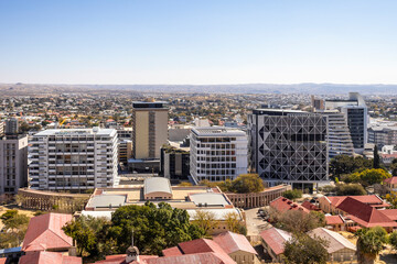Downtown Windhoek, Namibia, with tall contemporary buildings, wide streeodern ts, moving cars, and a clear blue sky.