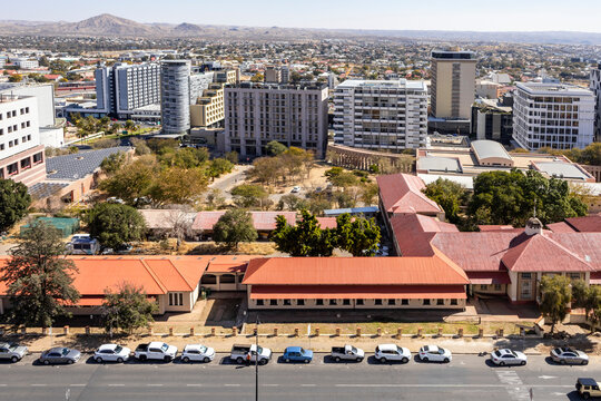 Downtown Windhoek, Namibia, with tall contemporary buildings, wide streeodern ts, moving cars, and a clear blue sky.