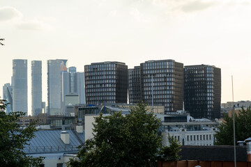 Modern Architecture Contrasts Against the Skyline of a Bustling City During Dusk, Showcasing a Blend of Old and New Structures
