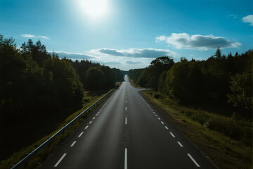 A scenic highway with clear sky and lush green trees on both sides