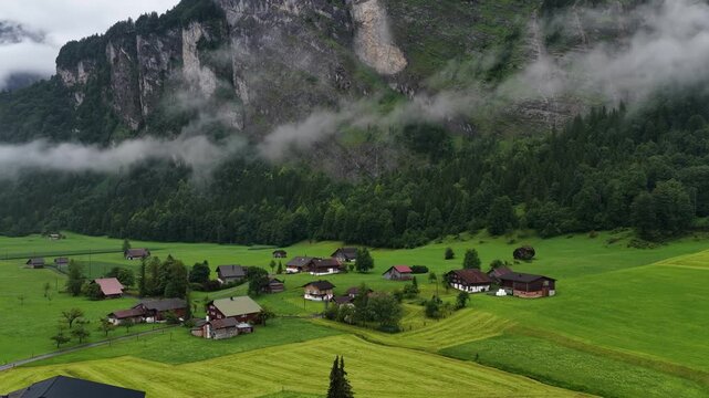 Drone aerial view of a swiss village in a foggy alpine valley