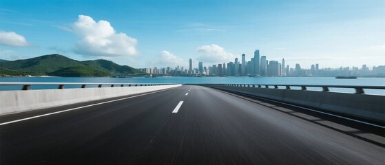 Obraz premium Smooth highway leading to modern city skyline under clear blue sky