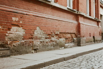 Old brick wall with visible damage on the street side
