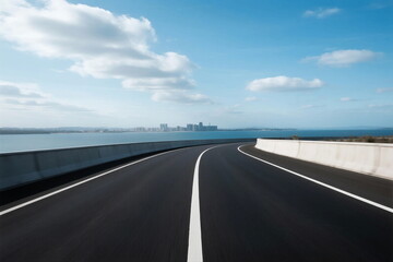 Fototapeta premium Smooth asphalt road stretching towards a scenic coastal view under a clear blue sky