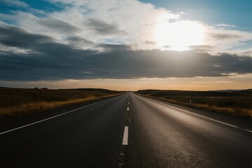 Long road stretching under a cloudy sky with sun shining through