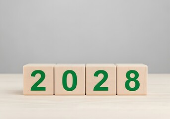 Four wooden blocks displaying the year two thousand and twenty eight in green against gray backdrop