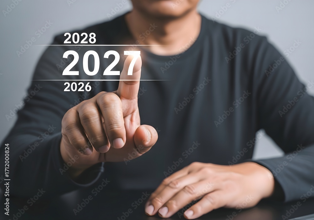 Poster person pointing at the year 2027 on a digital display with the years 2026 and 2028 also visible